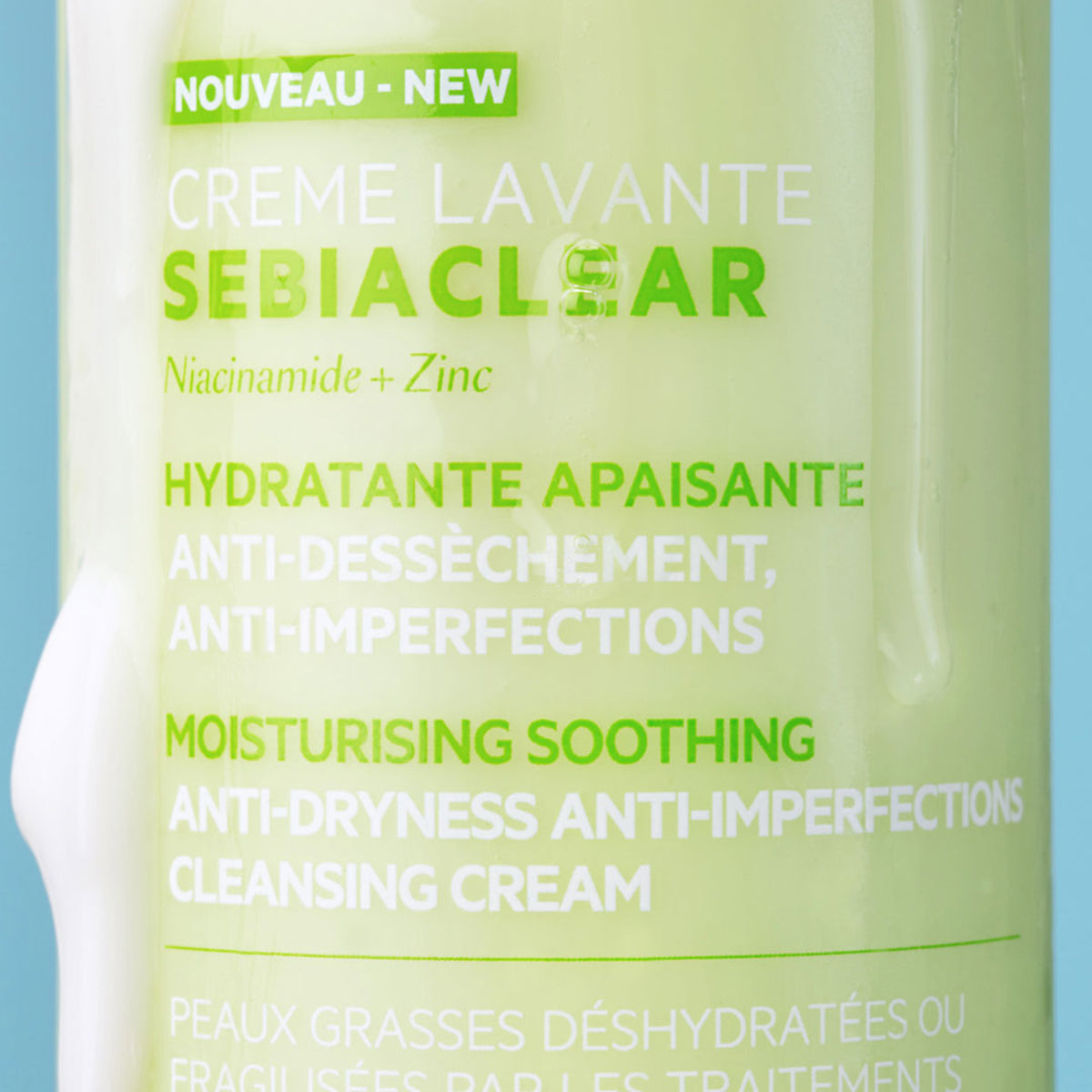 Close-up of a light green SEBIACLEAR Creme Lavante bottle with white text and a streak of white cleansing cream.