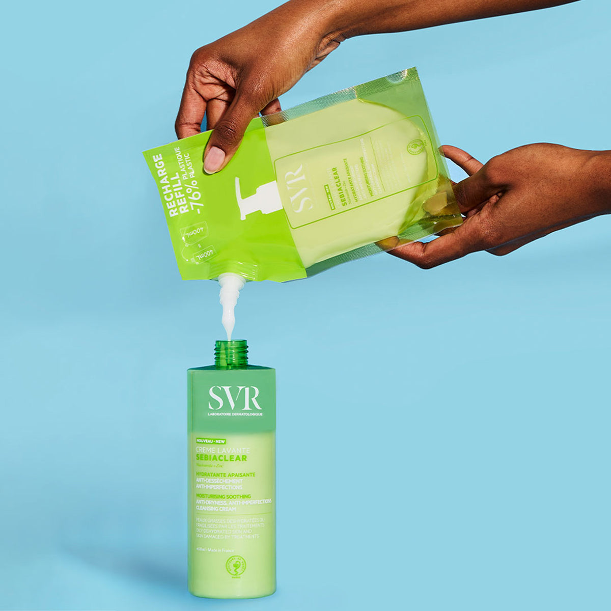 Hands pouring SVR Sebiaclear Creme Lavante refill pouch into a matching green 400ml pump bottle on a blue background.