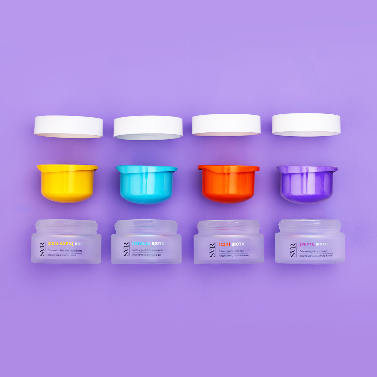 Four SVR Biotic 50ml cream jars with colorful inner lids and white caps arranged on a purple background.