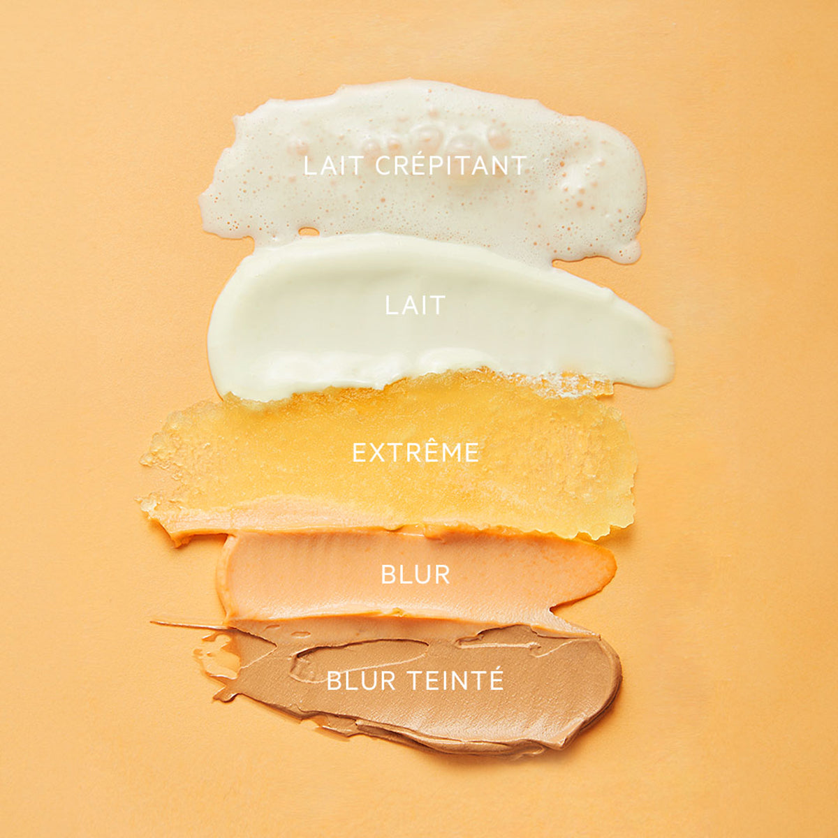 Five distinct skincare textures ranging from foamy white to tinted brown on a peach background.