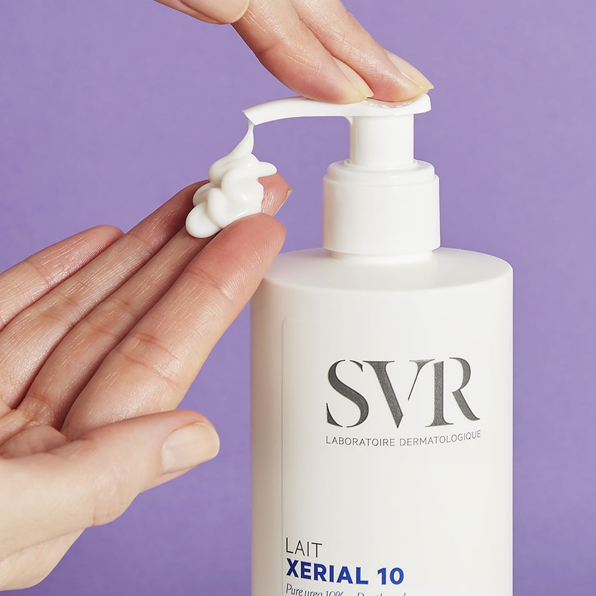 White SVR XERIAL 10 Lait pump bottle with a hand dispensing creamy white lotion against a purple background.