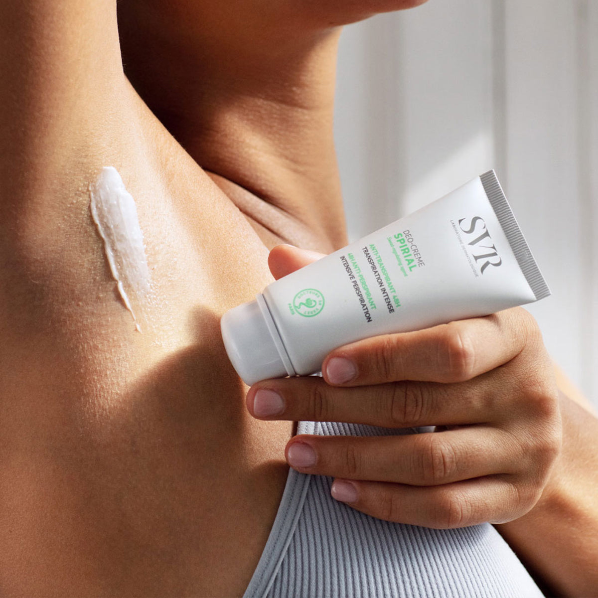 SVR Spirial Deo-Creme white squeeze tube being applied to underarm skin.
