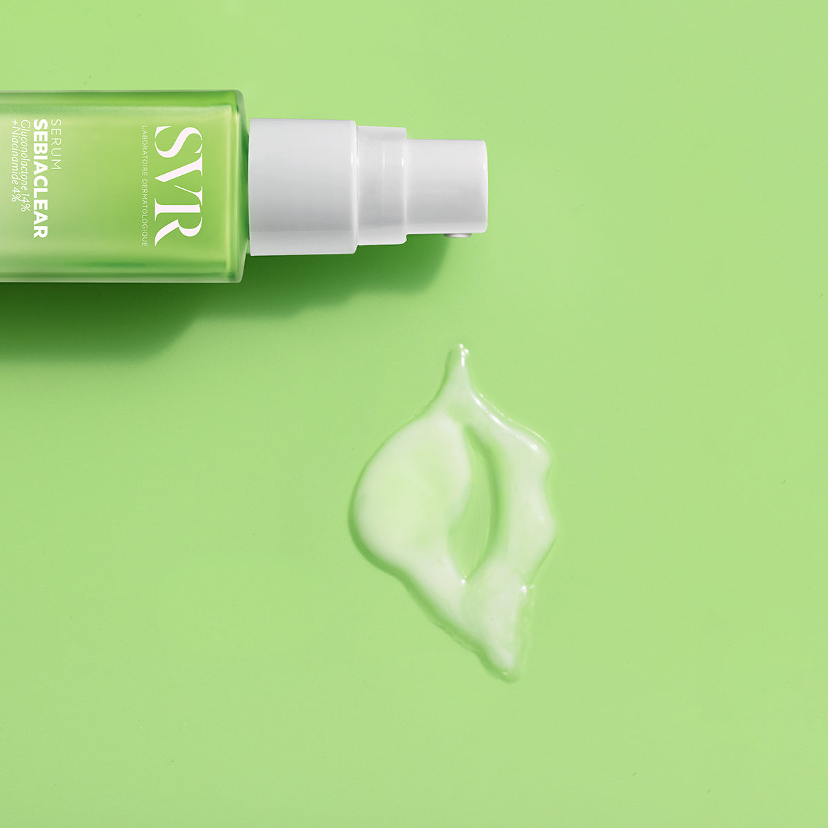 SVR Sebiaclear serum bottle with a white pump dispenser and a drop of light green gel on a matching green background.