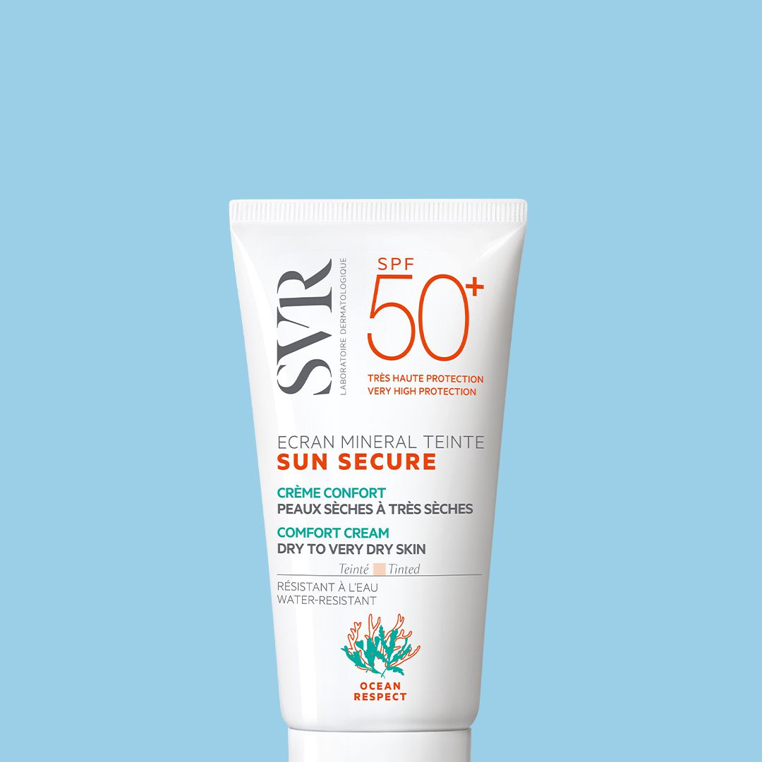 Tube de crème solaire teintée SVR Sun Secure SPF 50+ pour peaux sèches sur fond bleu clair.